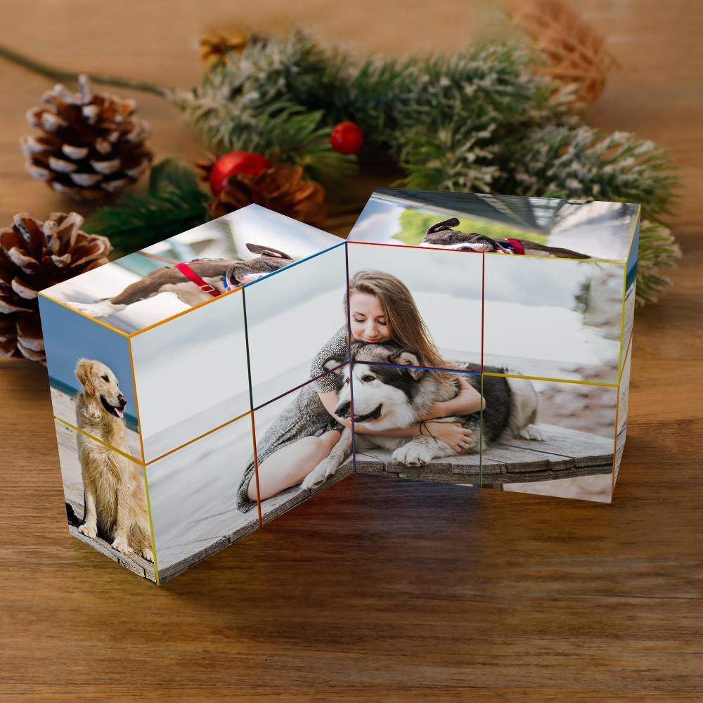 Three-panel photo cube displaying images of dogs and a woman hugging a husky, with seasonal pine decor and pine cones around, on a wooden surface.