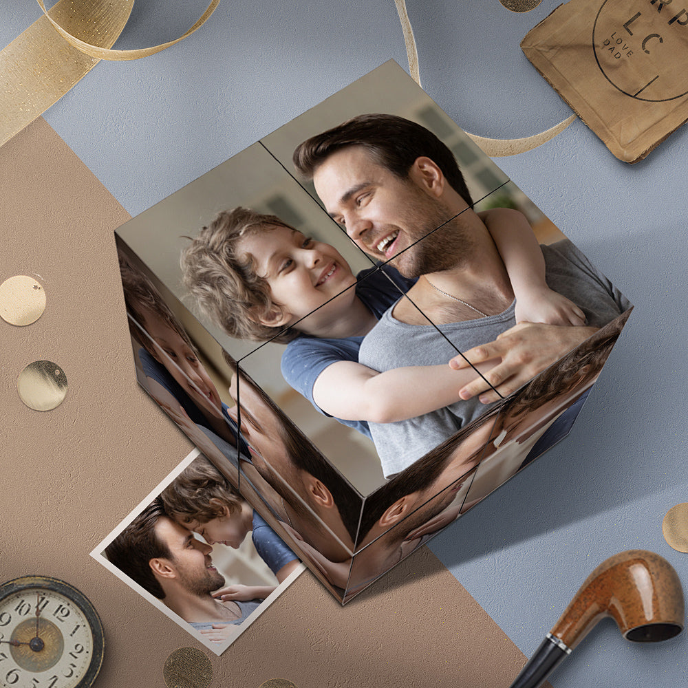 A heartwarming photo cube with images of a smiling child hugging a happy man, placed on a surface with decorative items like a clock and sequins.