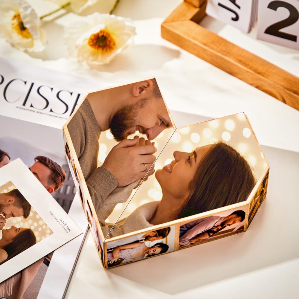 A couple's photo printed on a three-dimensional, heart-shaped ornament surrounded by flowers, a magazine, and a calendar block, displayed on a table.