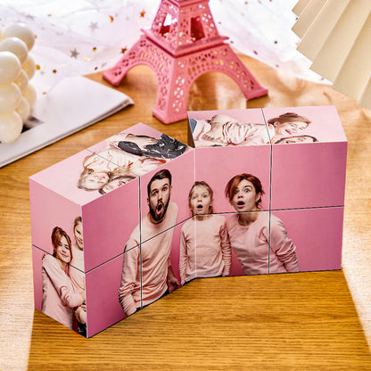 Custom photo puzzle cubes featuring a family portrait, arranged on a table next to a pink Eiffel Tower decoration and starry garland.